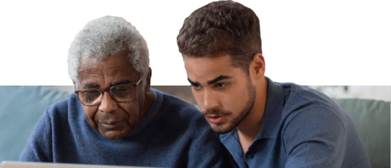 Young caregiver helping old man with a laptop