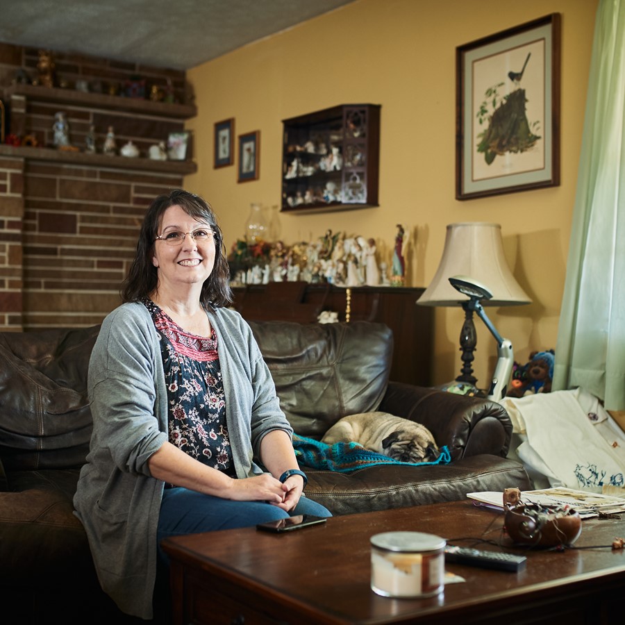 Female care worker sitting on couch and smiling at camera 