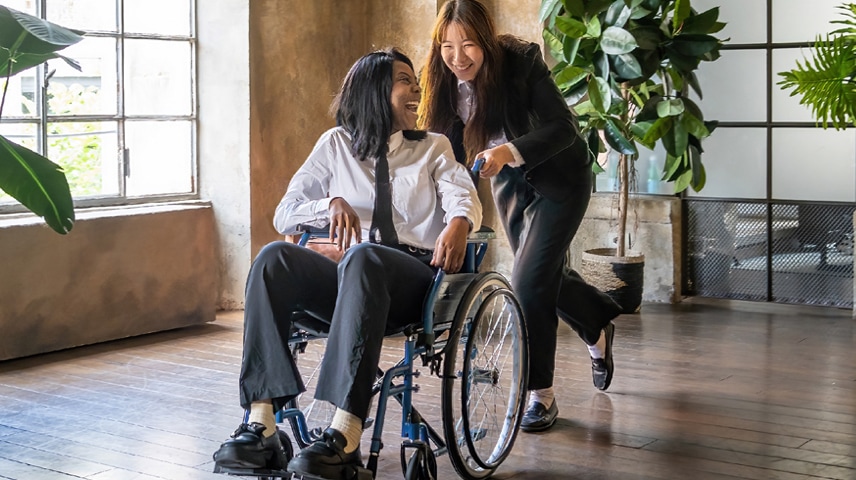 A caregiver pushing a person in a wheelchair