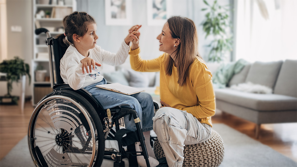 woman holding hands with a child in a wheelchair