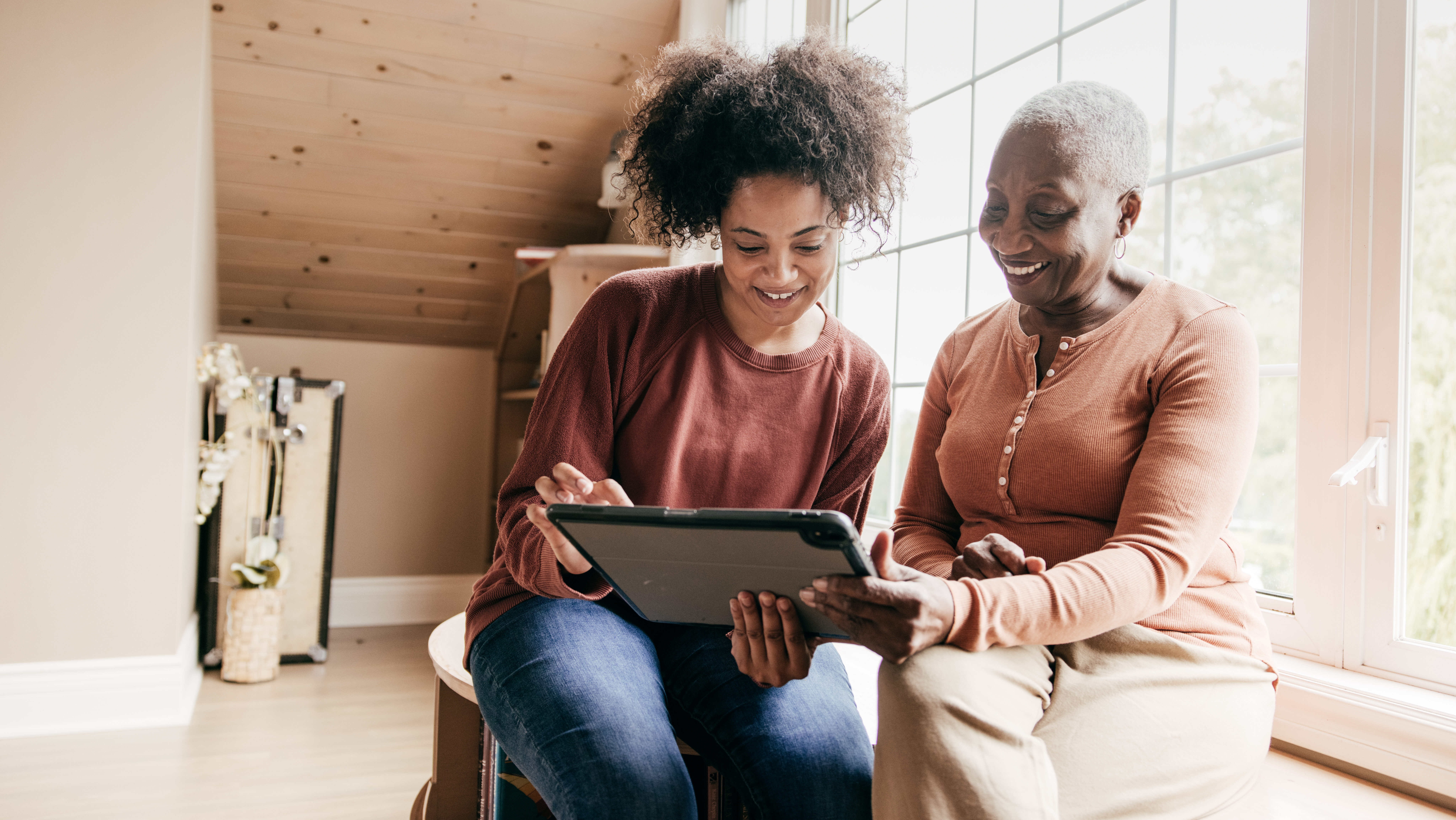 woman showing self-directed care options to another woman on a tablet