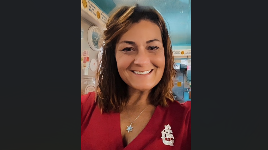 PPL employee Tracy T. smiling wearing a red shirt and ship broach