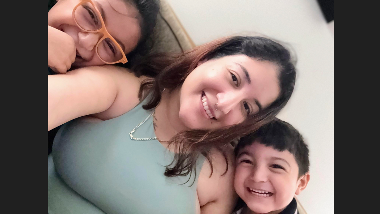adult woman smiling with her two smiling children