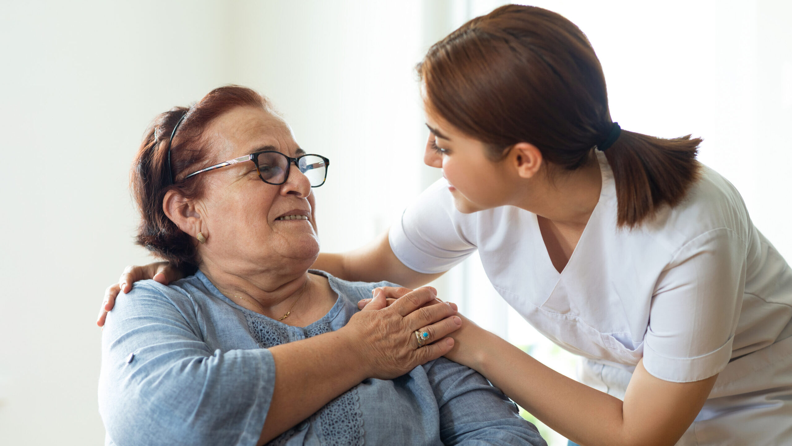 Caring nurse talks with her elderly patient