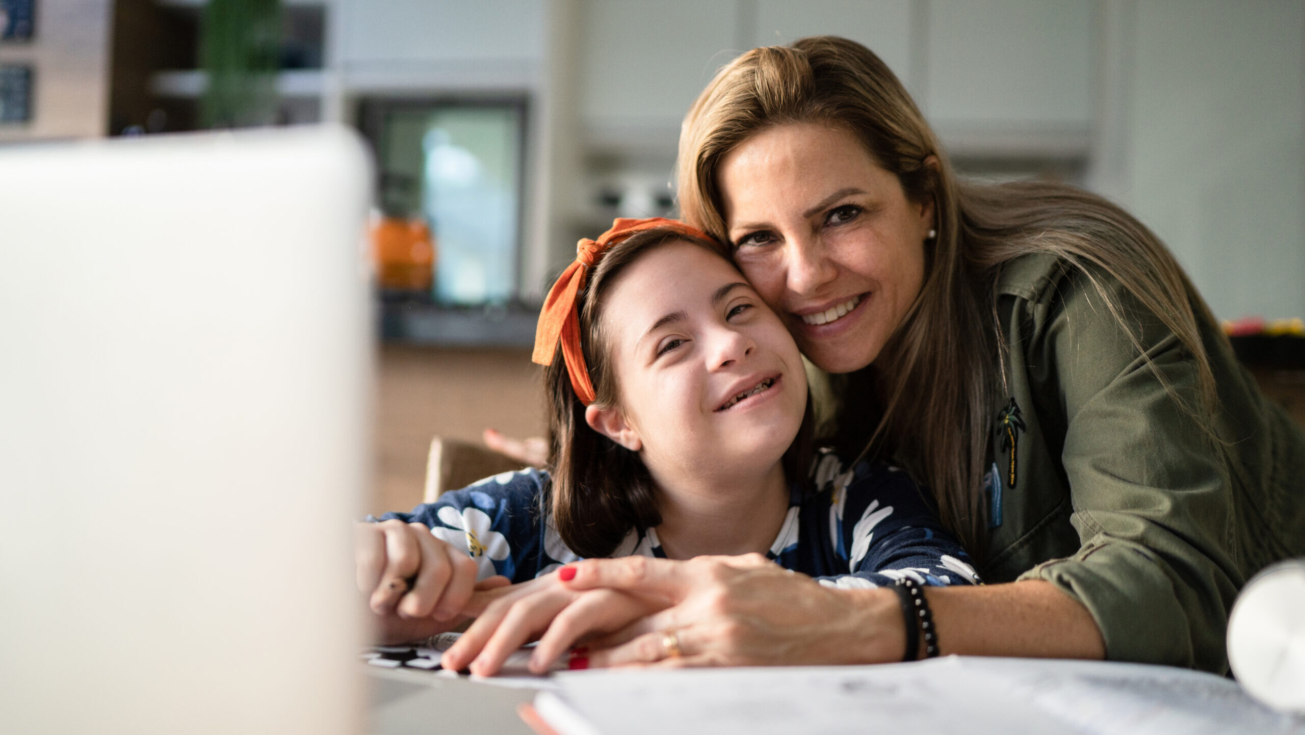 Portrait of mother and special needs daughter studying at home